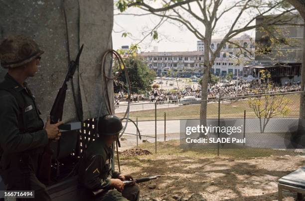 The New Case Of Panama. En 1964, au Panama, dans une rue proche de l'avenue Kennedy, des soldats américains, en treillis avec des casques et des...