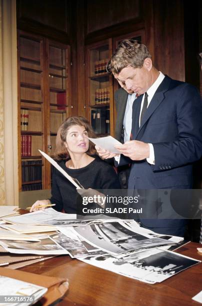 Preparation Of The Exhibition On John Fitzgerald Kennedy. Dans une bibliothèque, Jackie KENNEDY, en robe noire, attablée, choisissant des...