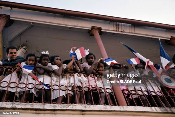 Official Travel Of General Charles De Gaulle To The Caribbean And Guyanne. Aux Antilles, sur un balcon, des fillettes en robe blanche, pressées...