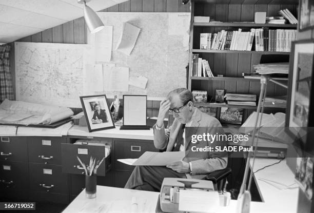 Rendezvous With Cornelius Ryan. Etats-Unis -22 mai 1964- Chez lui, Cornelius RYAN, portant des lunettes de vue, assis à son bureau lisant un document.