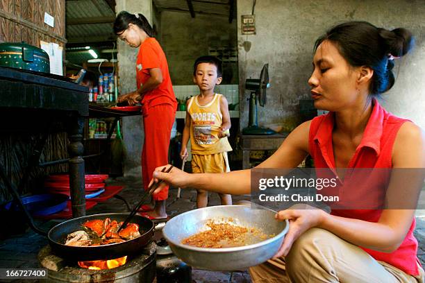 Woman preparing a crab dish in the kitchen of her restaurant in Vietnam..