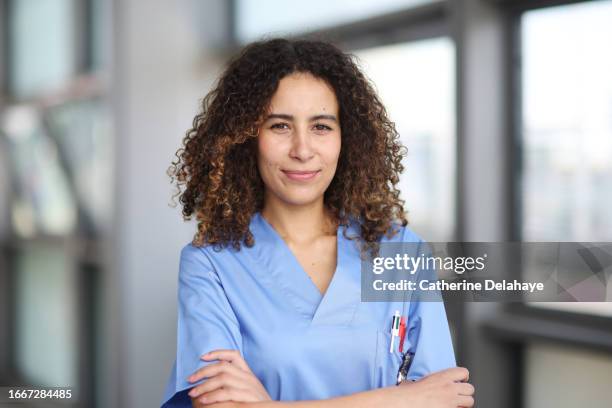 a nurse posing in a hospital corridor - infermiere foto e immagini stock
