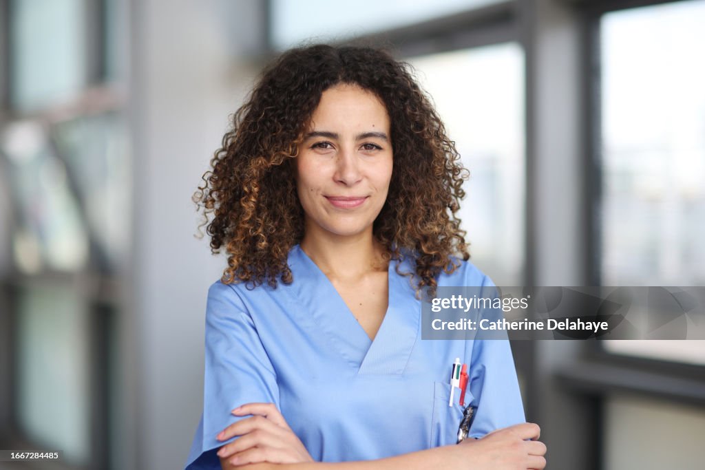 A nurse posing in a hospital corridor