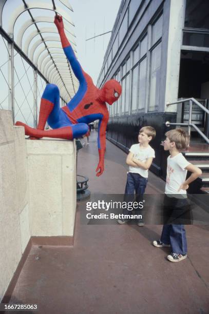 Actor Nick Hammond, wearing his 'Spider'Man' costume, is pictured with two young fans atop the Empire State Building in New York, July 11th 1977....