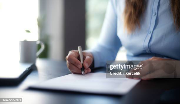 empresaria firmando un documento oficial - escribir fotografías e imágenes de stock