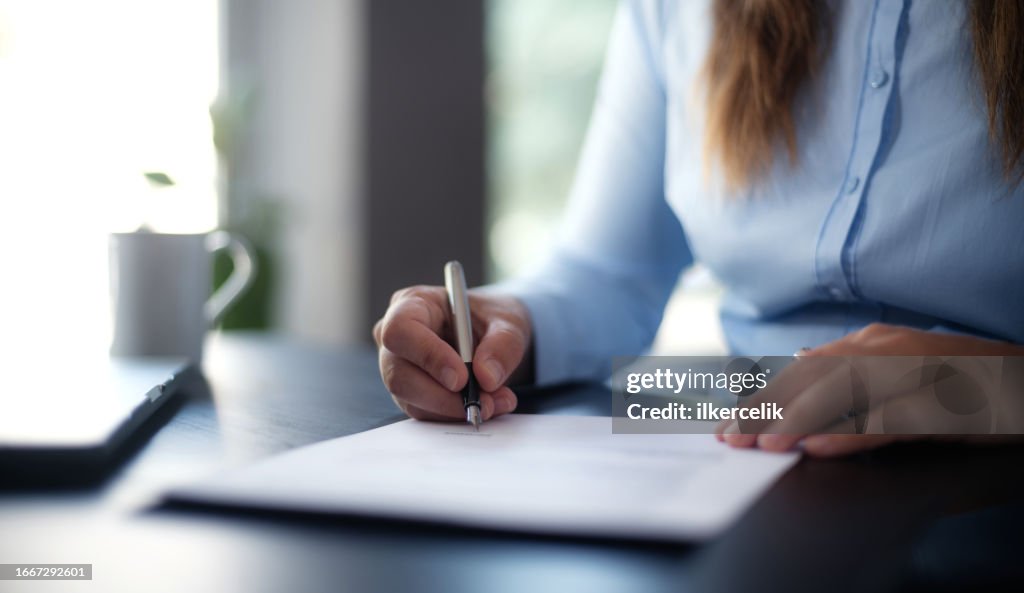 Businesswoman signing an official document
