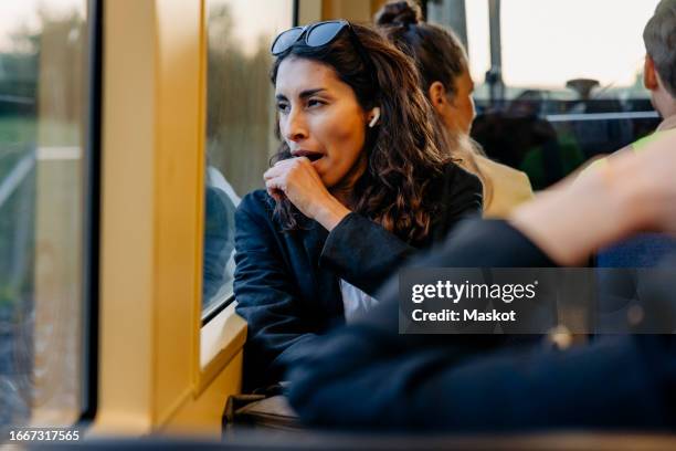 tired businesswoman yawning while traveling in tram - yawning stock-fotos und bilder