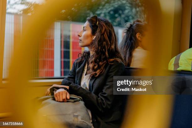 businesswoman looking out of window while traveling in tram - interior de comboio imagens e fotografias de stock