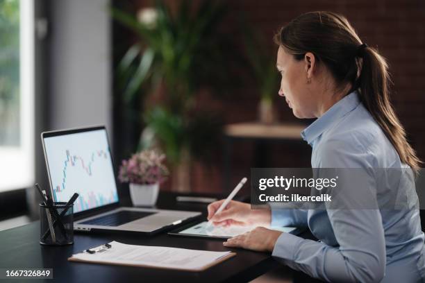 donna d'affari che controlla il suo investimento in borsa utilizzando il computer portatile - certificato azionario foto e immagini stock