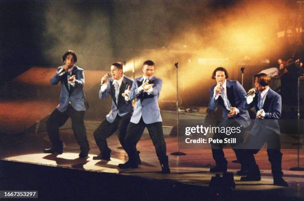 Robbie Williams, Jason Orange, Gary Barlow, Howard Donald and Mark Owen of English pop group Take That perform on stage at Wembley Arena on July...