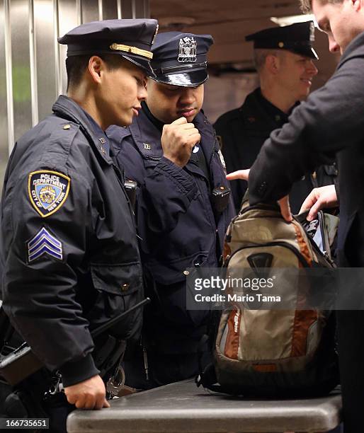 New York Police Department officers inspect bags at a subway entrance during the morning commute in Grand Central Terminal on April 16, 2013 in New...