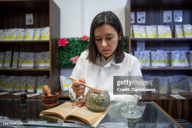 woman attending herbalist business - kruidengeneeskunde stockfoto's en -beelden