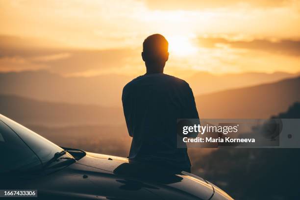 man stops his car to enjoy the sea during sunset. - car interior sunset stock pictures, royalty-free photos & images