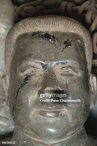 Stone bust of Pol Pot, leader of the Khmer Rouge regime, lies on the floor of the Tuol Sleng Museum in Phnom Penh along with chains and instruments...