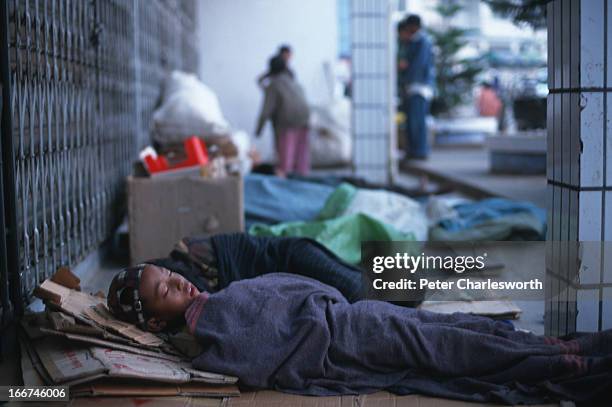 Street children sleep in a doorway early one morning in Muse, a border town with China. They work in the day time collecting recyclable paper and...