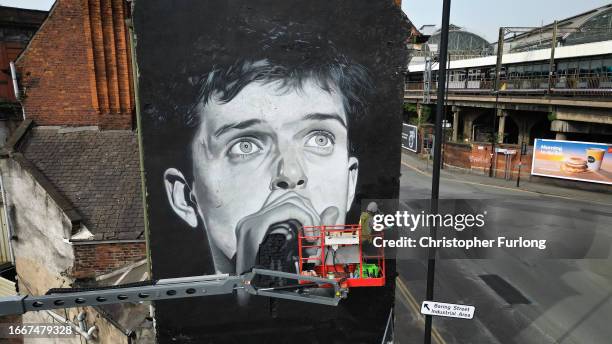 Street artist Akse P19 puts the finishing touches to his mural of Joy Division's Ian Curtis on the side of the Star & Garter pub on September 08,...