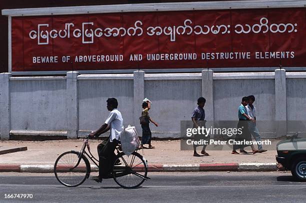 People walk past a billboard sign put up by the ruling military Junta in a street in central Rangoon. Burma is ruled by the State Law and Order...