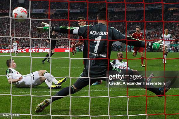 Mario Mandzukic of Muenchen scores the opening goal against Alexander Madlung of Wolfsburg and his keeper Diego Benaglio during the DFB Cup Semi...