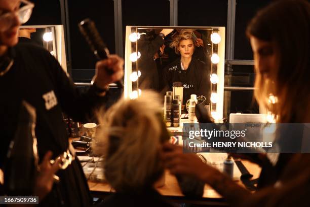 Model gets hair and makeup done backstage before Irish designer Paul Costelloe's catwalk presentation for his Spring/Summer 2024 collection during...
