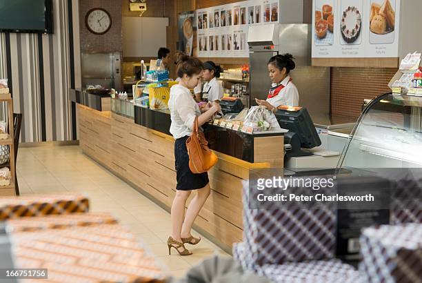 Customer makes a purchase at an S&P restaurant in Bangkok. The chain of S&P restaurants not only serves a la carte food, but also sells bakery items,...