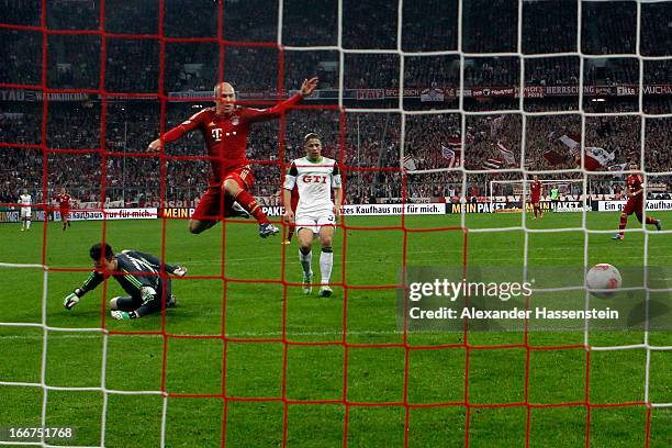 Arjen Robben of Muenchen scores the 2nd team goal against keeper Siego Benaglio of Wolfsburg and his team mate Ricardo Rodriguez during the DFB Cup...