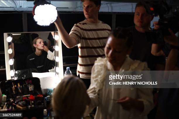 Model gets hair and makeup done backstage before Irish designer Paul Costelloe's catwalk presentation for his Spring/Summer 2024 collection during...