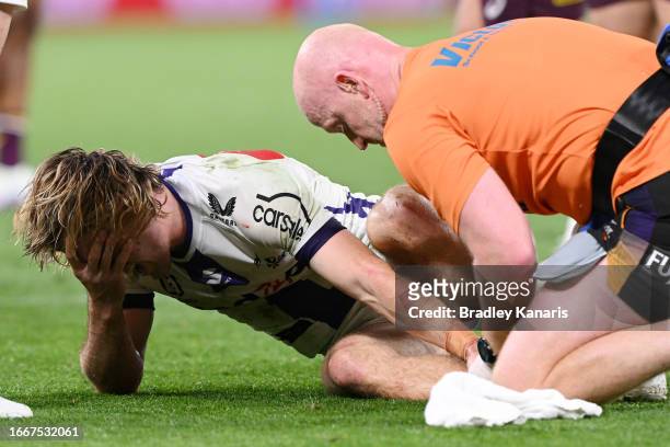 Ryan Papenhuyzen of the Storm is attended to by a team trainer after an ankle injury during the NRL Qualifying Final match between the Brisbane...
