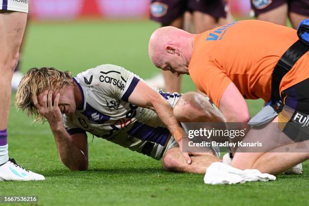 Ryan Papenhuyzen of the Storm is attended to by a team trainer after an ankle injury during the NRL Qualifying Final match between the Brisbane...