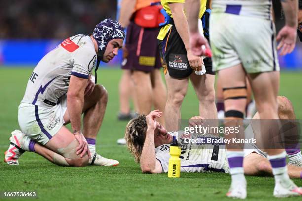 Ryan Papenhuyzen of the Storm is attended to by a team trainer after an ankle injury during the NRL Qualifying Final match between the Brisbane...