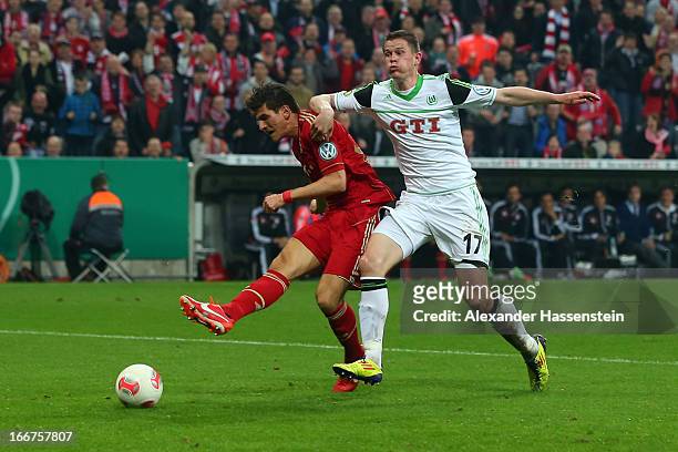 Mario Gomez of Muenchen scores the 5th team goal against Alexander Madlung of Wolfsburg during the DFB Cup Semi Final match between Bayern Muenchen...