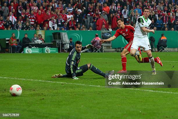 Mario Gomez of Muenchen scores the 5th team goal against Alexander Madlung of Wolfsburg and his keeoer Diego Benaglio during the DFB Cup Semi Final...