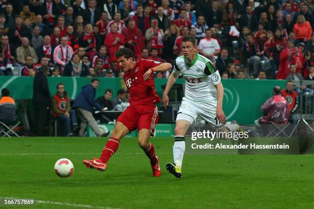 Mario Gomez of Muenchen scores the 6th team goal against Alexander Madlung of Wolfsburg during the DFB Cup Semi Final match between Bayern Muenchen...