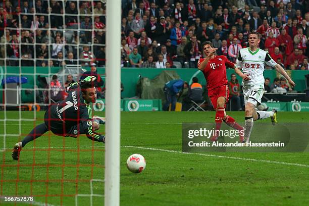 Mario Gomez of Muenchen scores the 6th team goal against Alexander Madlung of Wolfsburg and his keeoer Diego Benaglio during the DFB Cup Semi Final...