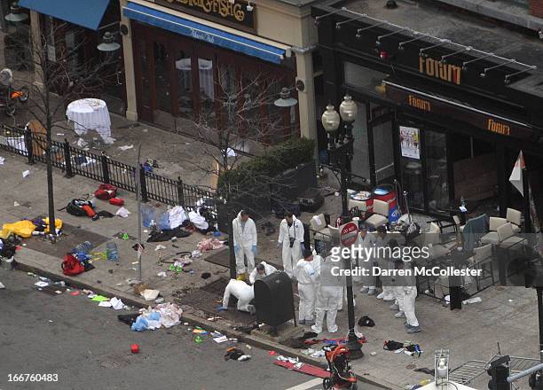Investigators in white jumpsuits work the crime scene on Boylston Street following yesterday's bomb attack at the Boston Marathon April 16, 2013 in...