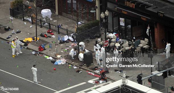 Investigators in white jumpsuits work the crime scene on Boylston Street following yesterday's bomb attack at the Boston Marathon April 16, 2013 in...