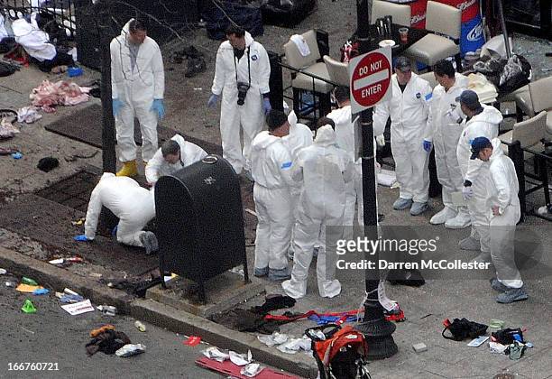 Investigators in white jumpsuits work the crime scene on Boylston Street following yesterday's bomb attack at the Boston Marathon April 16, 2013 in...