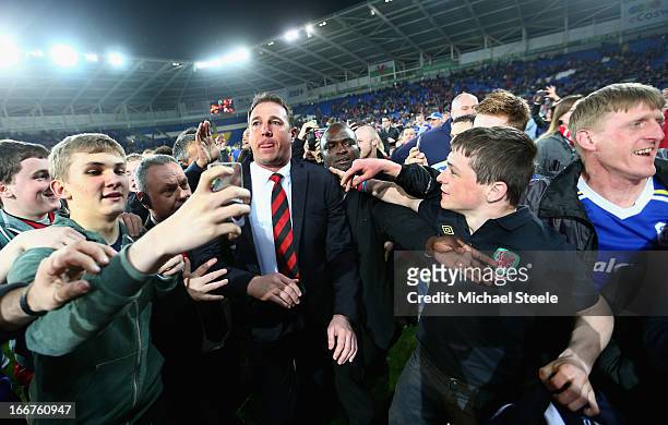 Cardiff City Manager Malky Mackay is mobbed by fans after his team's promotion to the Premier League at the end of the npower Championship match...