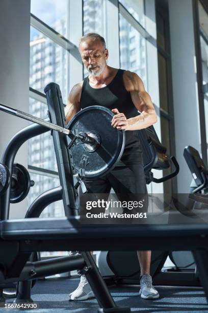 mature man preparing barbell for bench press exercise - bench press stock pictures, royalty-free photos & images