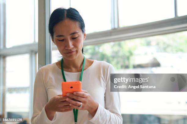 chinese woman using phone in an interior - asia telecom sms technology internet stock pictures, royalty-free photos & images