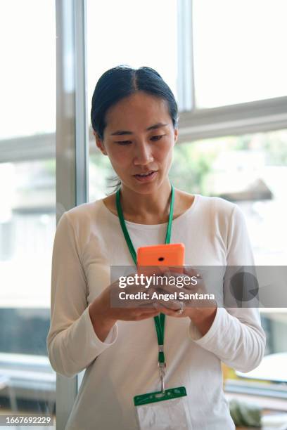 chinese woman using phone in an interior - female executive stock pictures, royalty-free photos & images