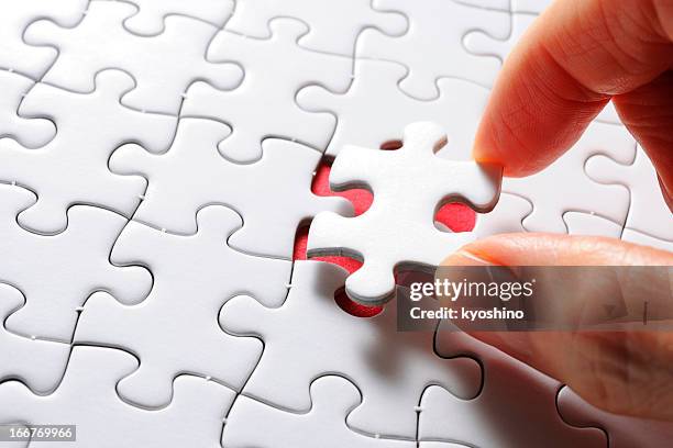 tenant un blanc vide dernière pièce du puzzle - dernière pièce du puzzle photos et images de collection