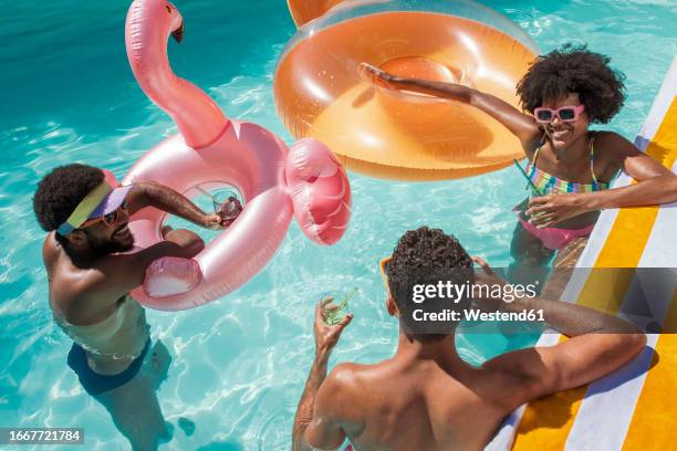 happy friends with inflatable swimming floats enjoying in pool - pool party stock pictures, royalty-free photos & images