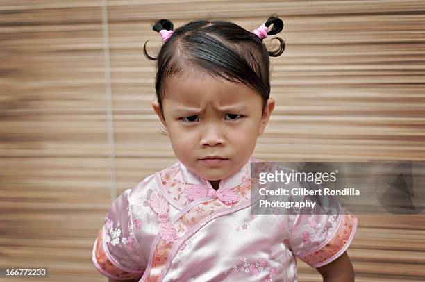 angry little girl wearing cheongsam - entrecerrar los ojos fotografías e imágenes de stock