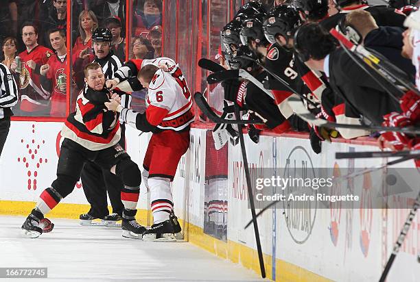 Chris Neil of the Ottawa Senators fights with Tim Gleason of the Carolina Hurricanes as players look on from the bench on April 16, 2013 at...