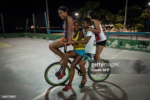 Teenagers enjoy a bike ride in the street in Fortaleza, state of Ceara, in northeastern Brazil, on April 16, 2013. AFP PHOTO/Yasuyoshi CHIBA
