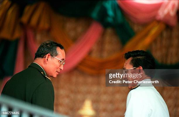 His Majesty, King Bhumibol Adulyadej of Thailand, talks to his Prime Minister, Chuan Leekpai during the opening ceremony of the Pa Sak Jolasid Dam, a...
