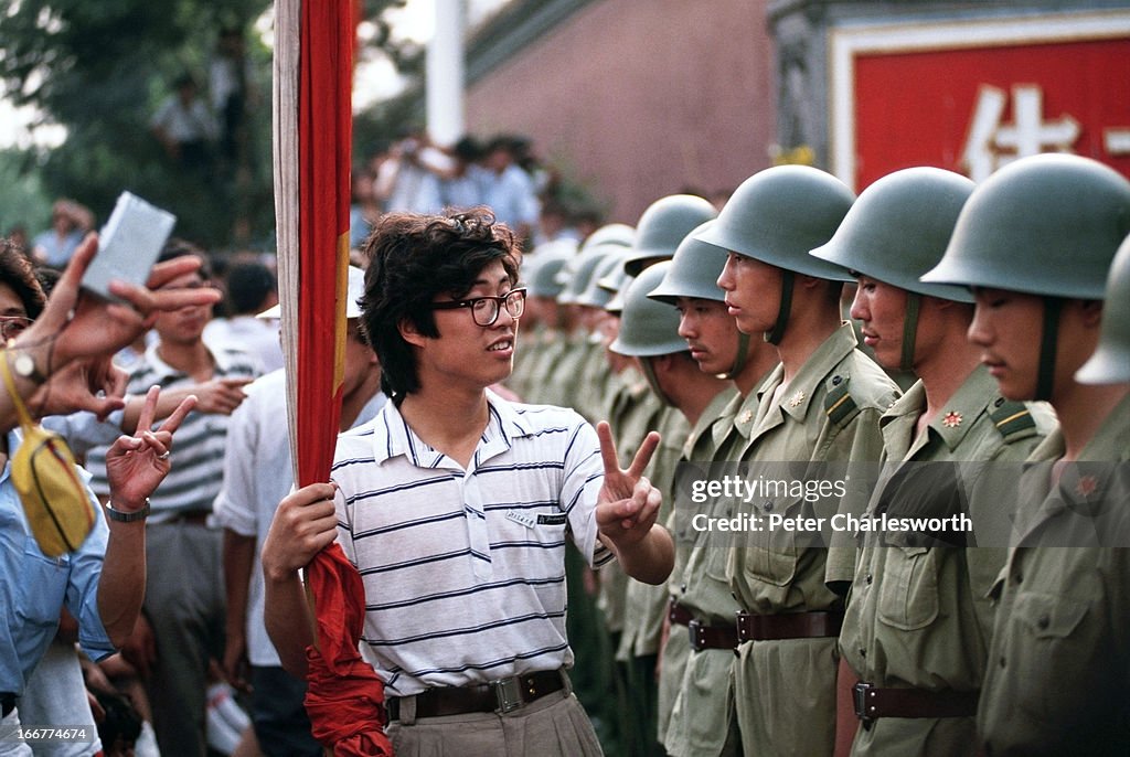 A pro-democracy demonstrator gives the V for Victory sign to...