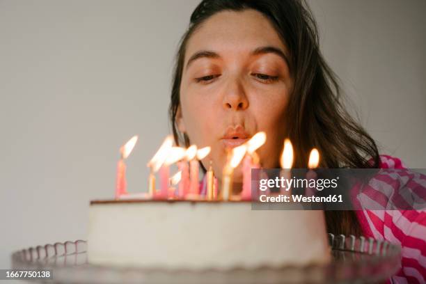 woman blowing candles on birthday cake - souffle photos et images de collection