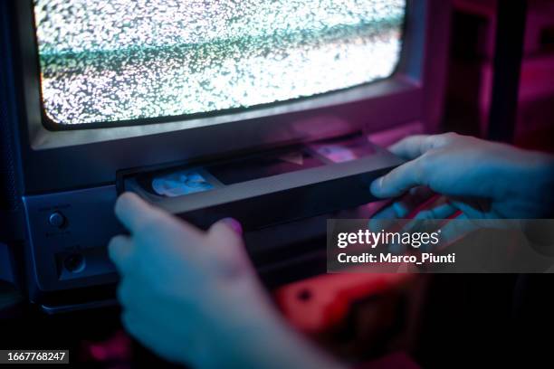 hände führen vhs in alten kathodenschirm ein - hineinstecken stock-fotos und bilder