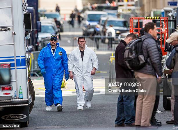 Investigators walked down Exeter Street from Boylston Street, following yesterday's explosions near the finish line of the Boston Marathon on...